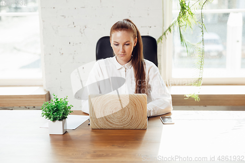 Image of Caucasian young woman in business attire working in office