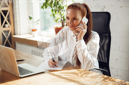 Image of Caucasian young woman in business attire working in office