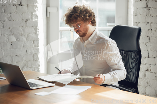 Image of Caucasian young man in business attire working in office, job, online studying