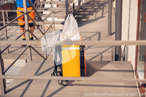 Image of Contacless delivery service during quarantine. Man delivers food and shopping bags during isolation