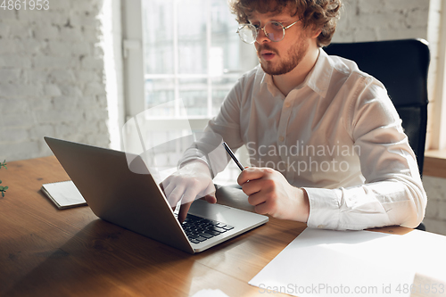 Image of Caucasian young man in business attire working in office, job, online studying