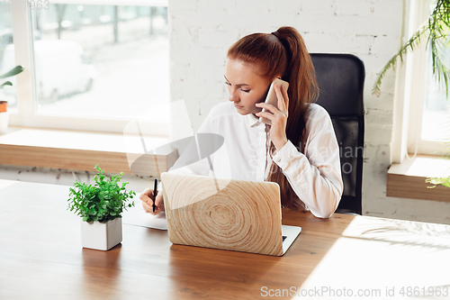 Image of Caucasian young woman in business attire working in office