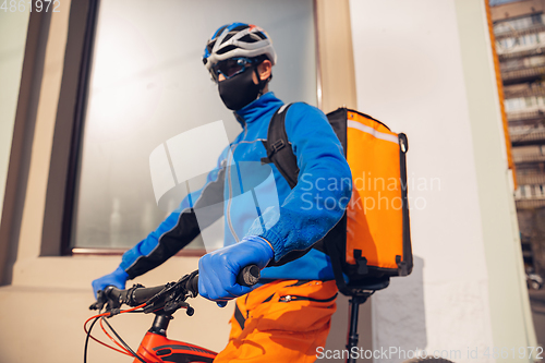 Image of Contacless delivery service during quarantine. Man delivers food and shopping bags during isolation