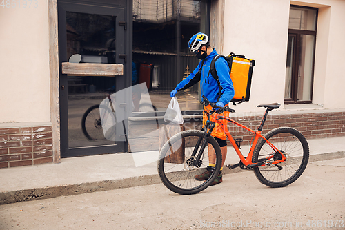 Image of Contacless delivery service during quarantine. Man delivers food and shopping bags during isolation