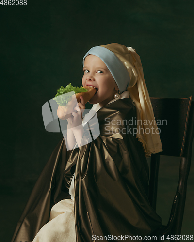 Image of Medieval little girl as a lady with a pearl earring on dark studio background. Concept of comparison of eras, childhood. Stylish creative design, art vision, new look of artwork.