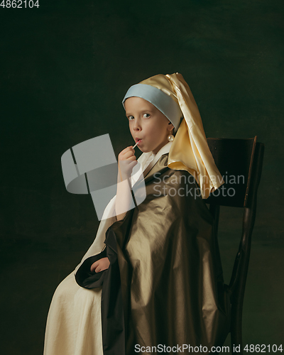 Image of Medieval little girl as a lady with a pearl earring on dark studio background. Concept of comparison of eras, childhood. Stylish creative design, art vision, new look of artwork.