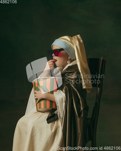 Image of Medieval little girl as a lady with a pearl earring on dark studio background. Concept of comparison of eras, childhood. Stylish creative design, art vision, new look of artwork.