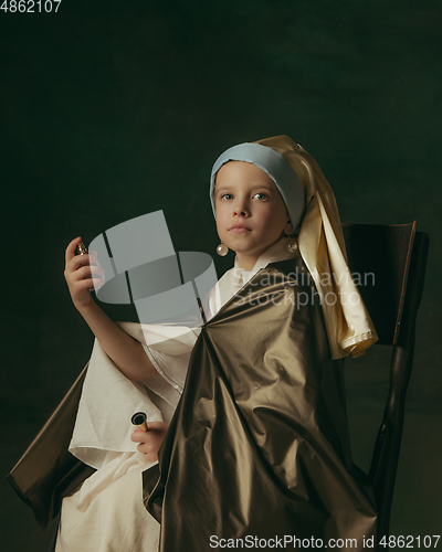 Image of Medieval little girl as a lady with a pearl earring on dark studio background. Concept of comparison of eras, childhood. Stylish creative design, art vision, new look of artwork.