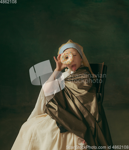 Image of Medieval little girl as a lady with a pearl earring on dark studio background. Concept of comparison of eras, childhood. Stylish creative design, art vision, new look of artwork.