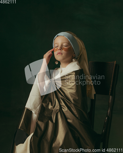 Image of Medieval little girl as a lady with a pearl earring on dark studio background. Concept of comparison of eras, childhood. Stylish creative design, art vision, new look of artwork.