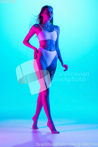 Image of Beautiful female body on blue background in purple neon light. Beauty, cosmetics, spa, depilation, diet and treatment, fitness concept.