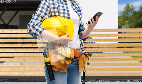 Image of woman or builder with phone and working tools