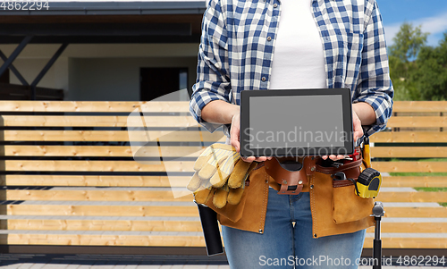 Image of woman builder with working tools showing tablet pc