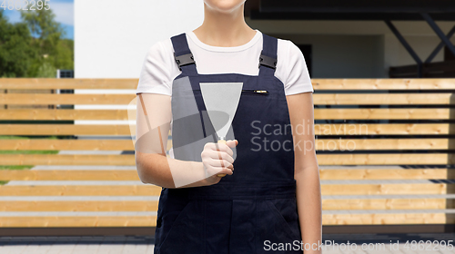 Image of close up of female builder with putty knife