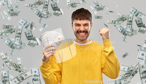 Image of happy young man with money celebrating success