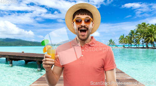 Image of happy man in straw hat with juice on beach