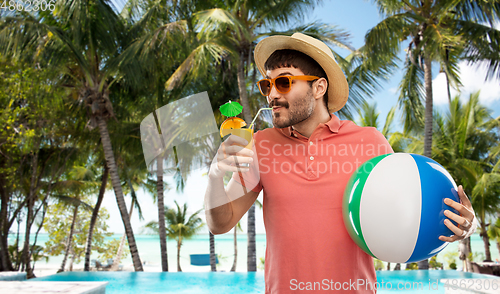 Image of happy man in straw hat with juice on beach