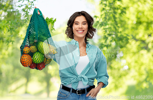 Image of happy smiling woman with food in reusable net bag