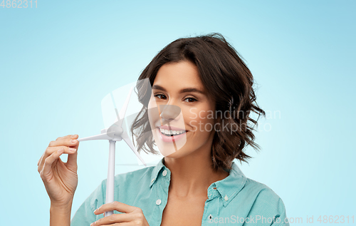 Image of happy smiling young woman with toy wind turbine