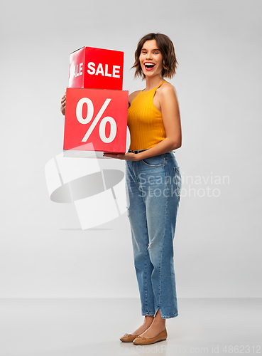 Image of happy smiling young woman with sale signs