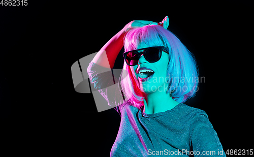 Image of happy woman in pink wig and sunglasses dancing