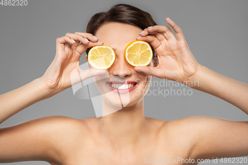 Image of beautiful woman making eye mask of lemon slices