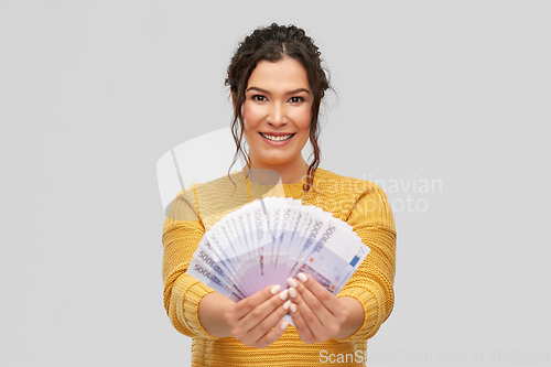 Image of happy smiling young woman with euro money