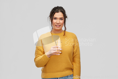 Image of smiling young woman with water in glass