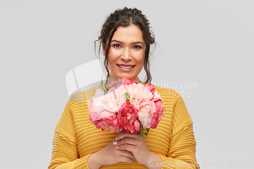 Image of happy smiling young woman with bunch of flowers