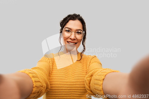 Image of smiling woman with pierced nose taking selfie