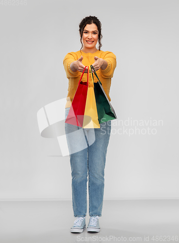 Image of happy smiling young woman with shopping bags