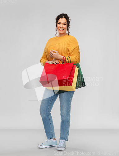 Image of happy smiling young woman with shopping bags