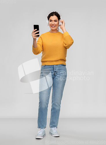 Image of woman in headphones with smartphone