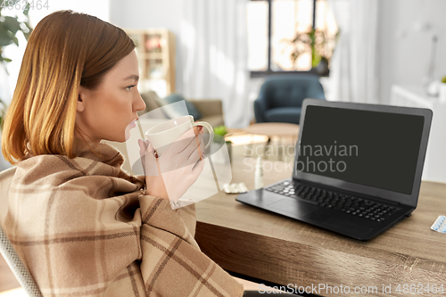 Image of sick woman with tea having video call on laptop