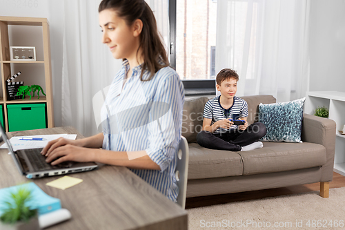 Image of boy with gamepad playing video game at home