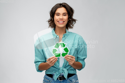 Image of smiling young woman holding green recycling sign