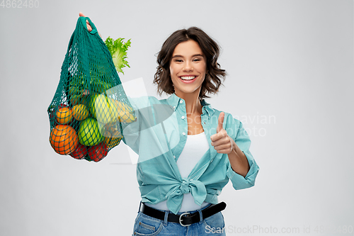 Image of happy smiling woman with food in reusable net bag