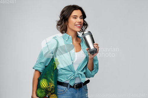 Image of happy smiling woman with food in reusable net bag