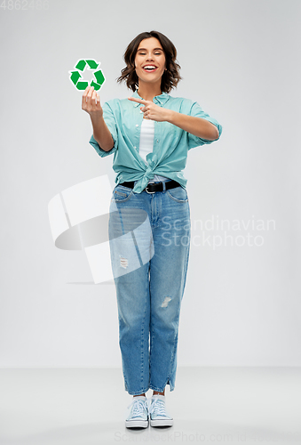 Image of smiling young woman holding green recycling sign