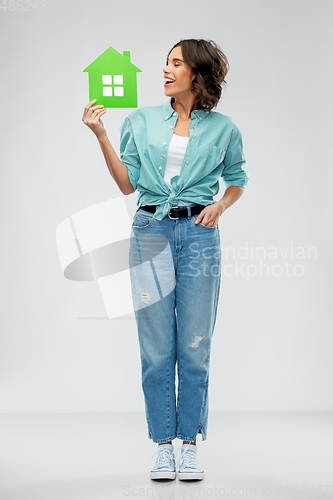 Image of smiling young woman holding green house