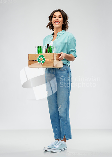 Image of smiling young woman sorting glass waste