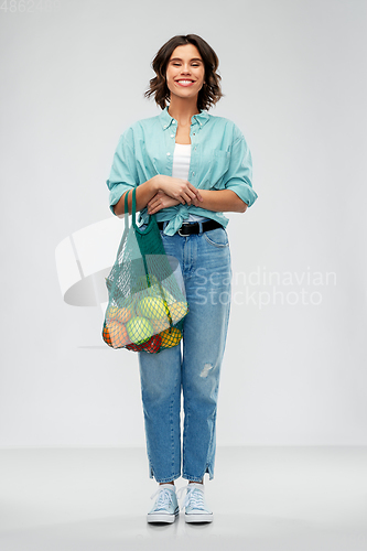 Image of happy smiling woman with food in reusable net bag