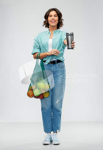 Image of happy smiling woman with food in reusable net bag