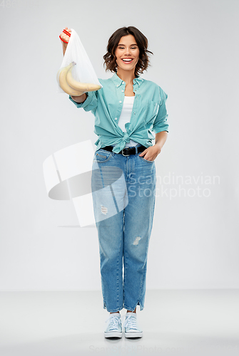 Image of happy woman with bananas in reusable string bag