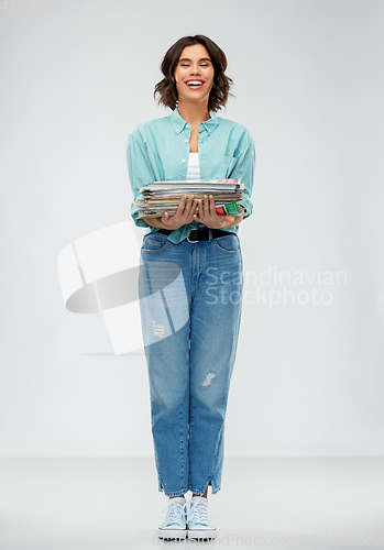 Image of smiling young woman sorting paper waste