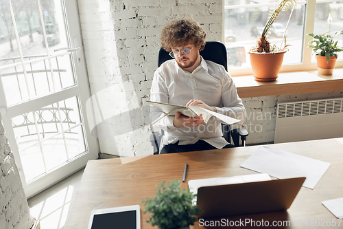 Image of Caucasian young man in business attire working in office, job, online studying