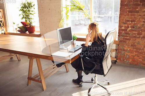 Image of Caucasian young woman in business attire working in office