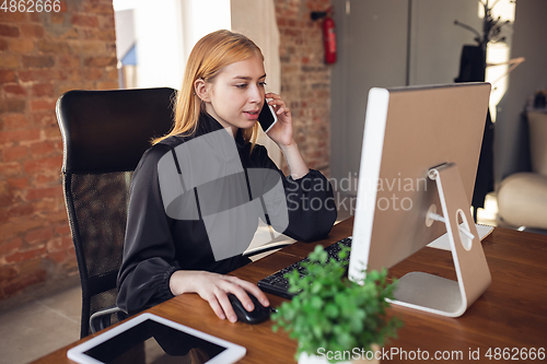 Image of Caucasian young woman in business attire working in office