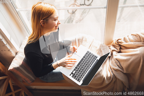 Image of Young woman using gadgets to watch cinema, photos, online courses, taking selfie or vlog, online shopping