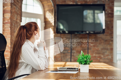 Image of Caucasian young woman in business attire working in office